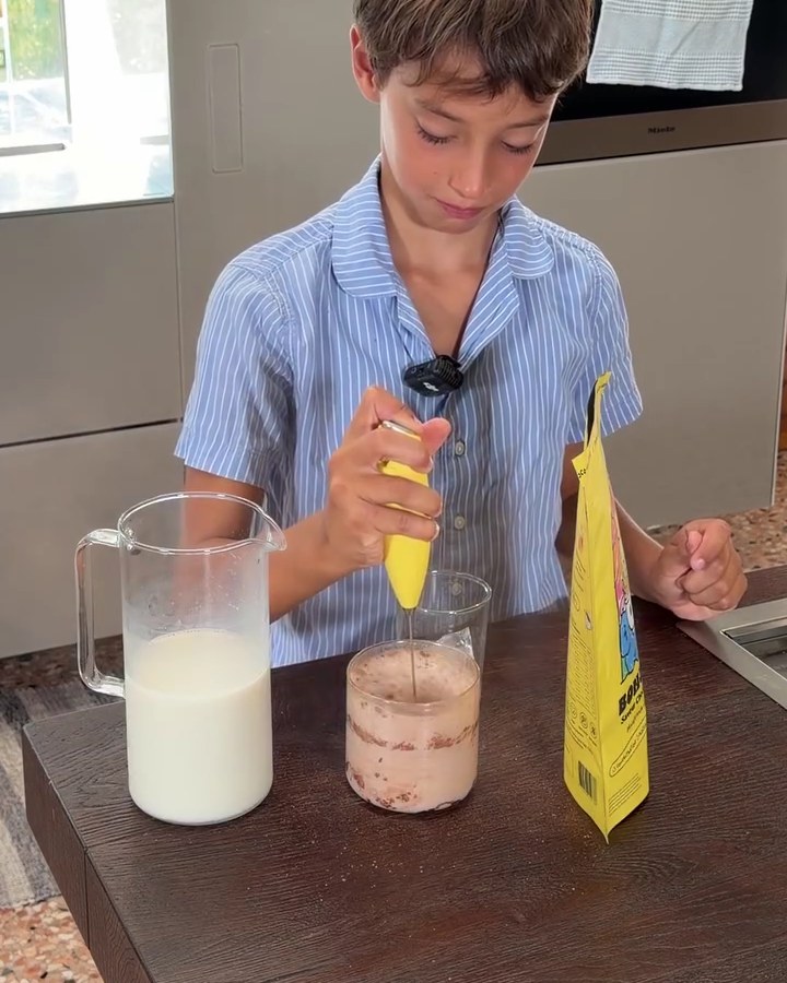 A boy frothing his Bonjour Kids chocolate drink at the kitchen counter